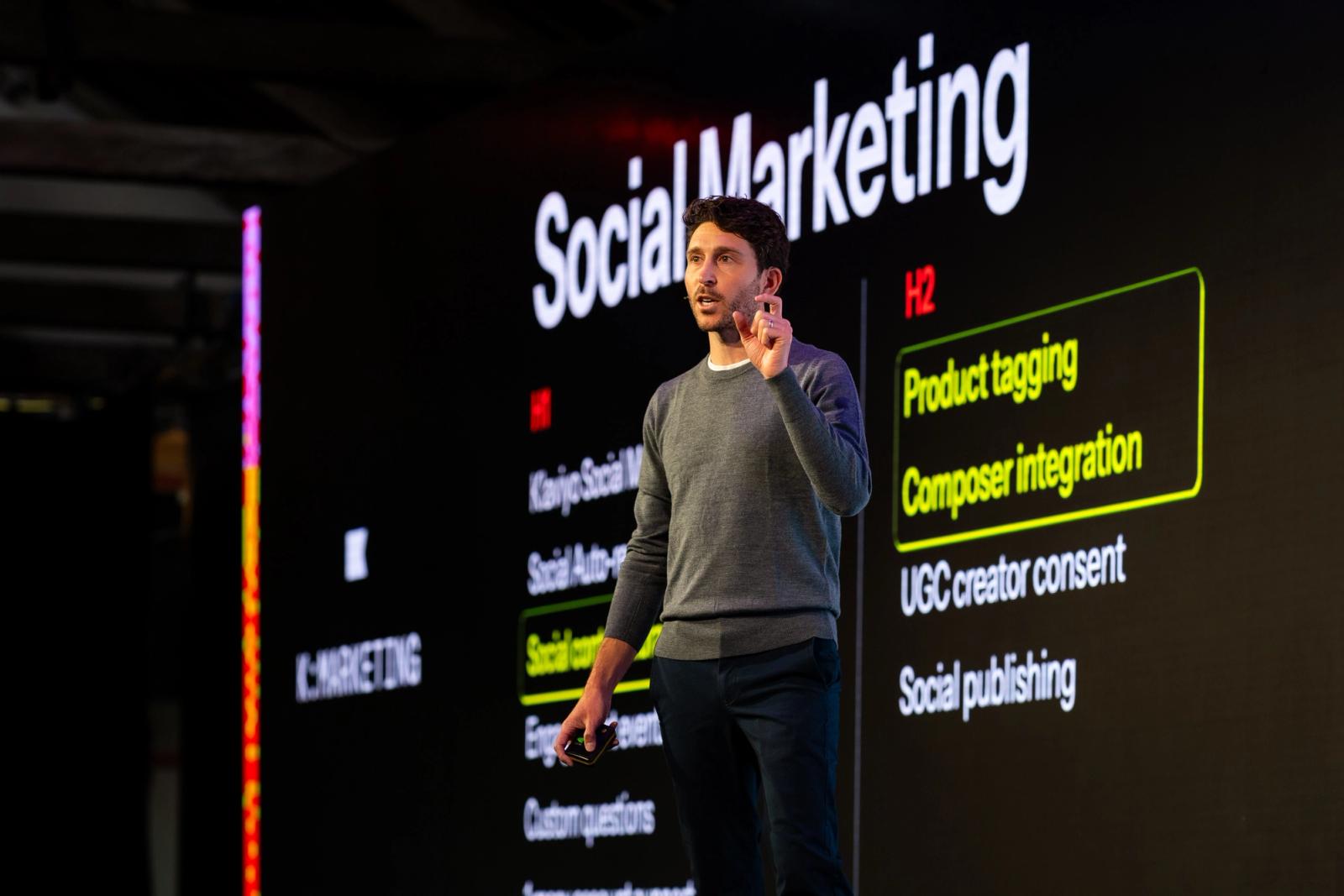 A man presents in front of a screen displaying 'Social Marketing' and highlighted text 'Product tagging' and 'Composer integration'.