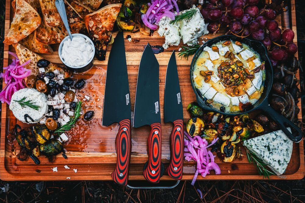 Three Montana Knife Company knives on a charcuterie board.