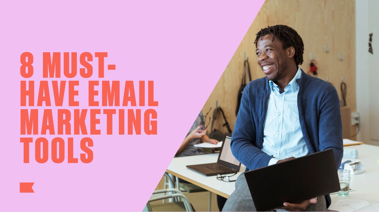 Smiling man holding a laptop beside text reading “8 must-have email marketing tools.”