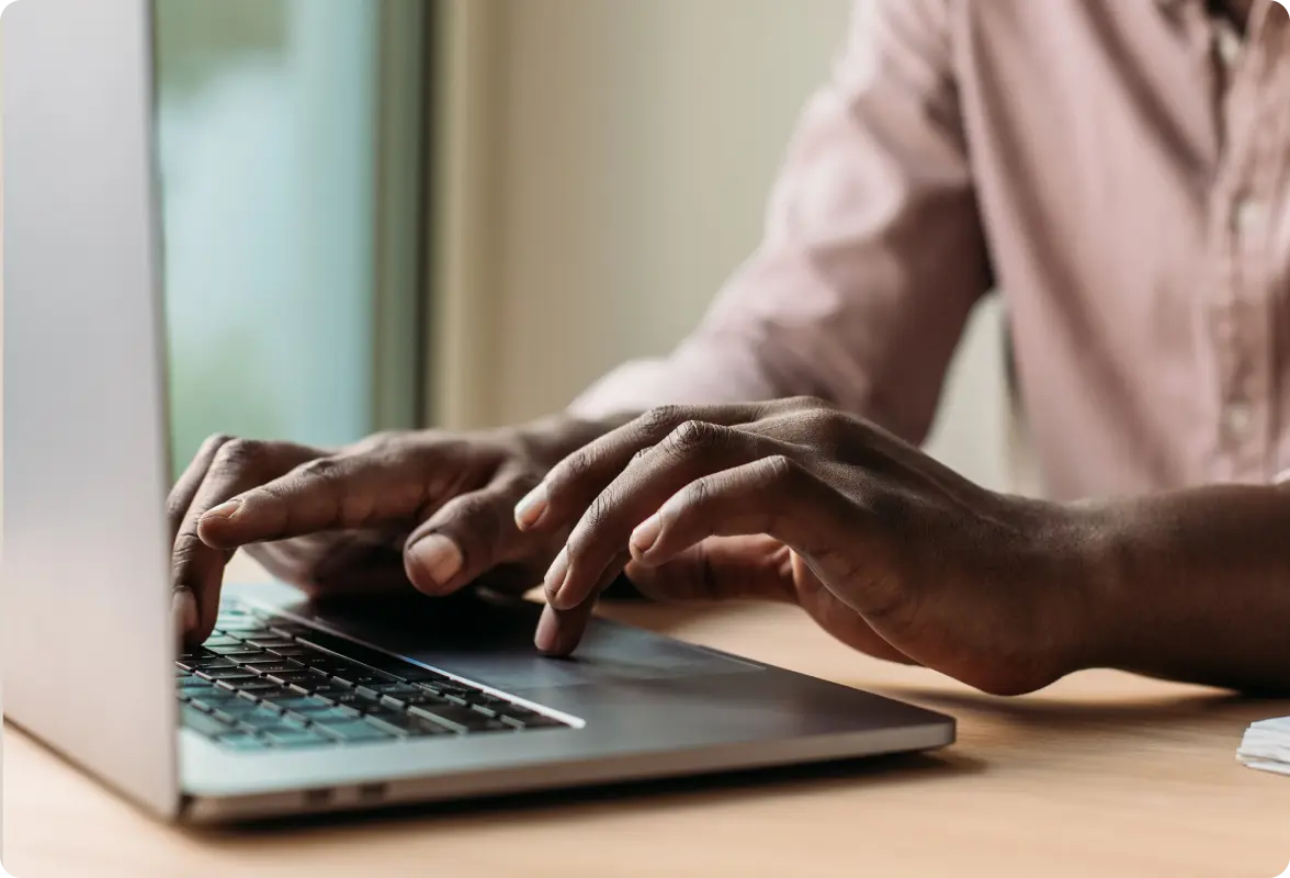 Person typing on a laptop at a desk.