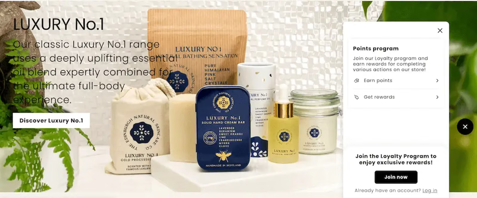 Image shows a fly-out form on the Edinburgh Skincare website which appears when they click on a teaser in the lower right corner. The form encourages visitors to join the brand’s loyalty program for access to exclusive rewards. The form also features an large image of several skincare products set on a white table, including a large light orange pouch of bath salts, a white pouch of skincare product, several jars and bottle of skincare product in white and yellow, and a navy blue tin containing a solid hand cream bar.