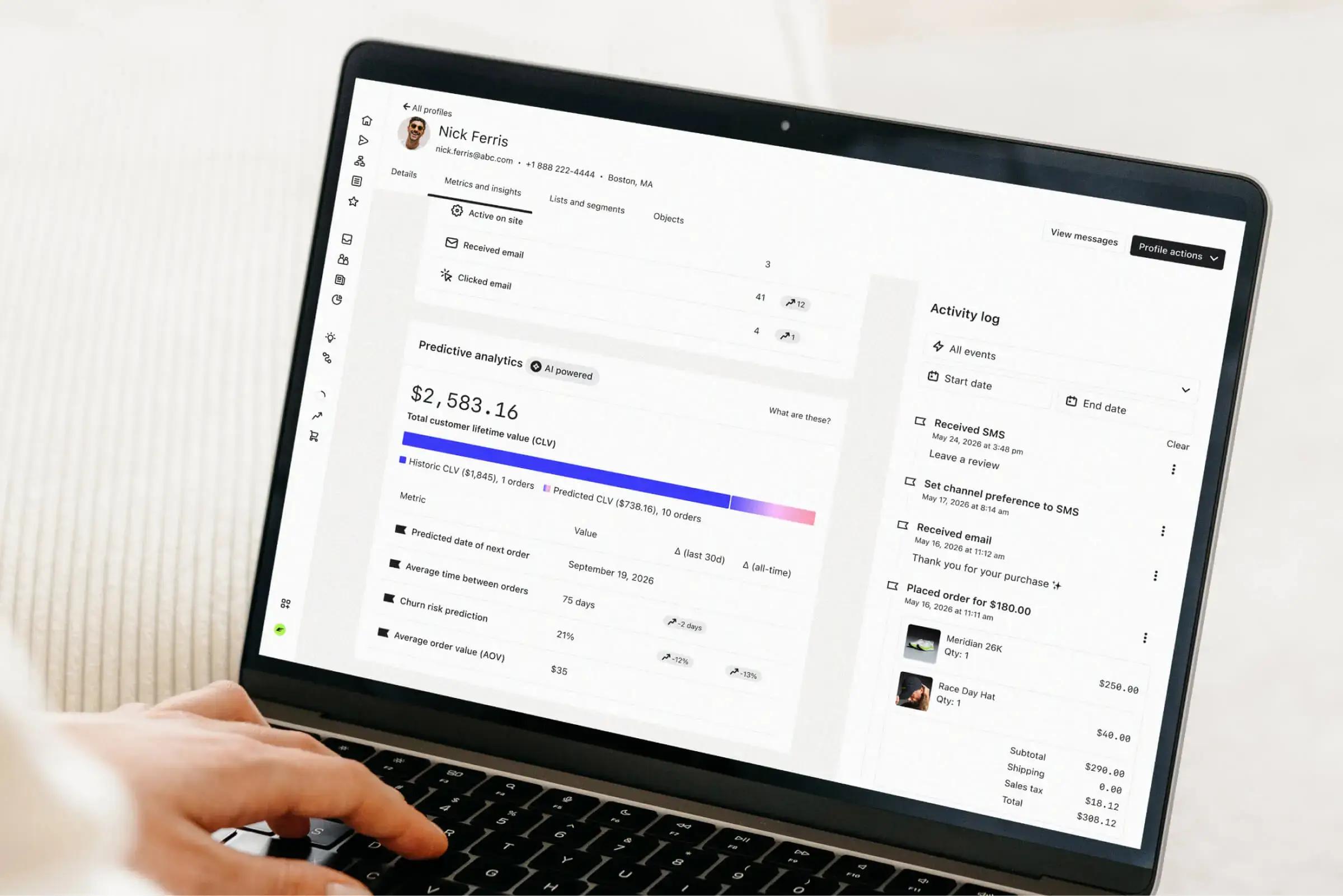 Person using a laptop displaying a customer profile, predictive analytics, and activity log.