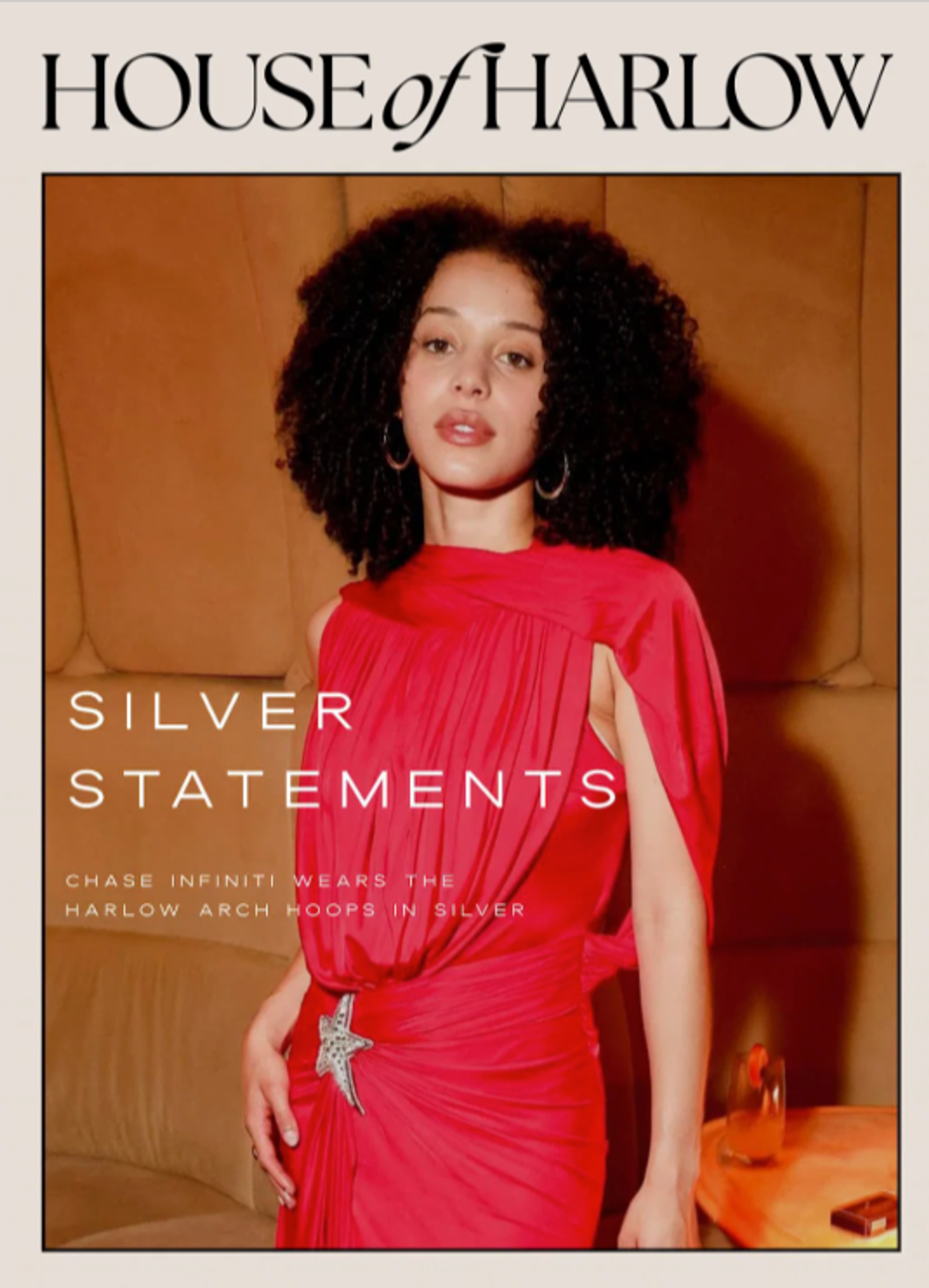 Below a simple House of Harlow logo in black text is a photo of up-and-coming celebrity Chase Infiniti, who has dark skin and dark hair styled in shoulder-length dark curls. She is wearing House of Harlow silver arch loop earrings and an elegant red dress with a silver star-shaped buckle on one side of her hip. Overlaid on top of the image is the headline, “Silver Statements," with a subhead that reads, “Chase Infiniti wears the Harlow arch hoops in silver.”