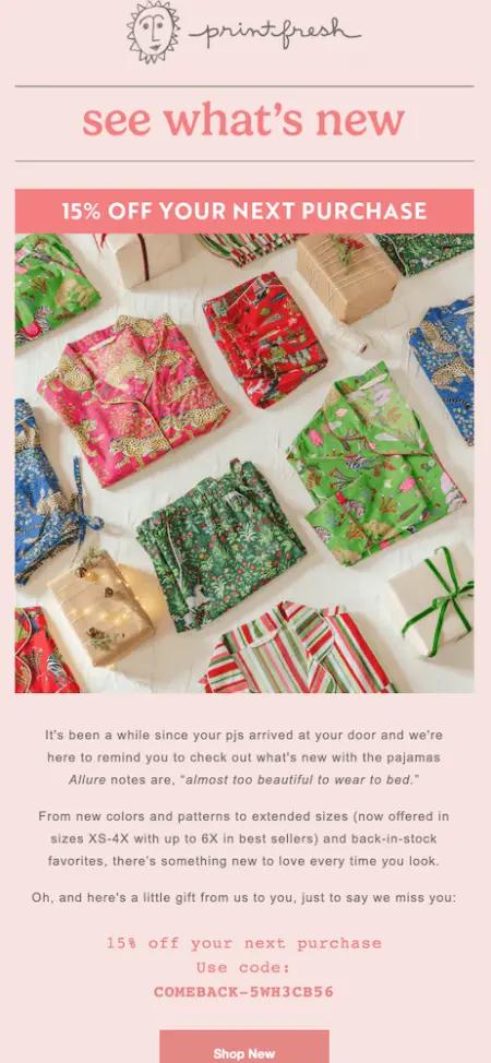 Image shows a pink email with a hero image of folded pajamas of various patterns and colors. Above the image is text that offers 15% off a next purchase, with a “Shop Now” call-to-action button in pink underneath the image and some explanatory text.