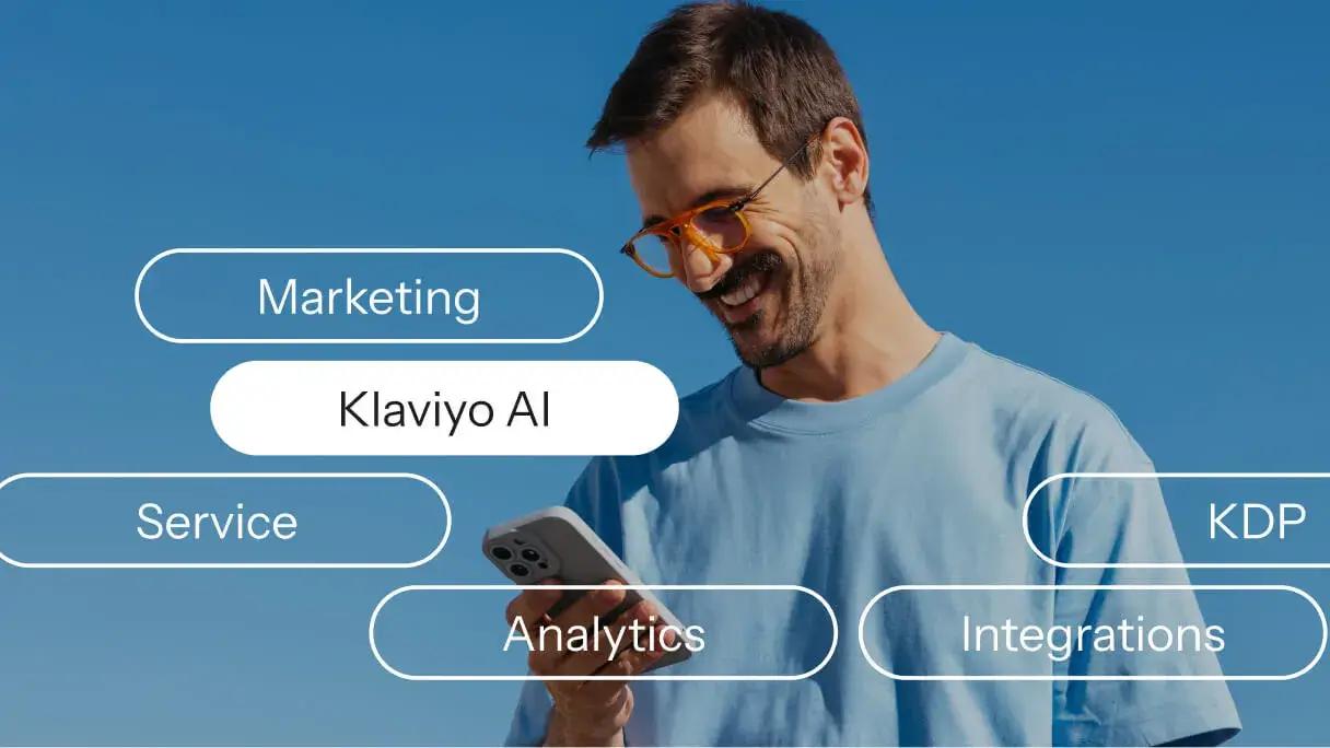Smiling man looks at his phone amid labels for Klaviyo AI, marketing, service, analytics, KDP and integrations.