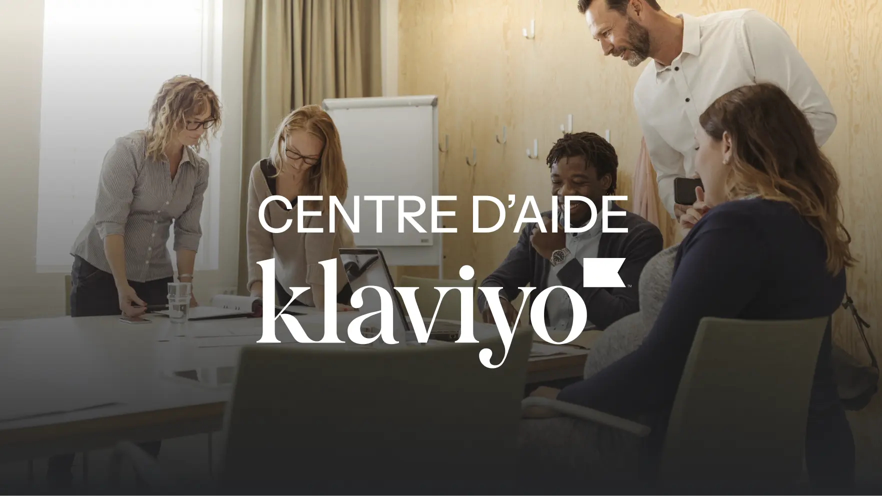 Groupe de personnes travaillant ensemble autour d'une table, texte "Centre d'aide Klaviyo" superposé.