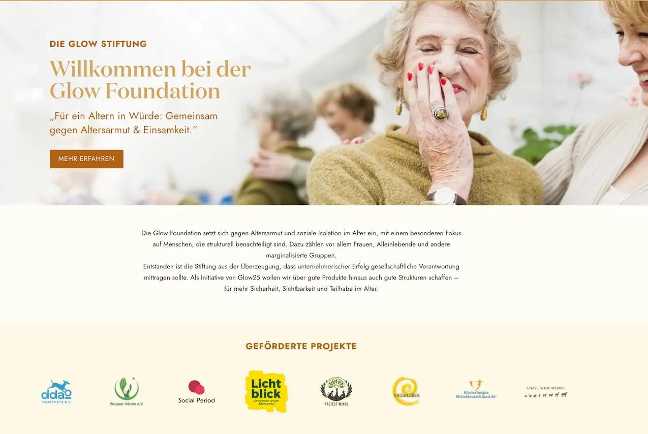 Ältere Frau lächelt, umarmt von einer anderen Person. Text: "Willkommen bei der Glow Foundation" und Informationen zur Stiftung.