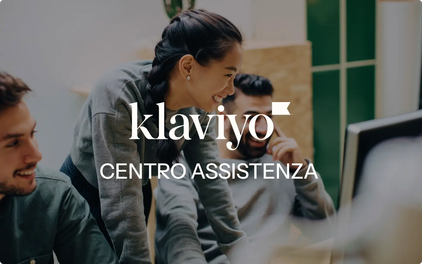 Persone sorridenti lavorano insieme al computer. Testo: "Klaviyo Centro Assistenza".