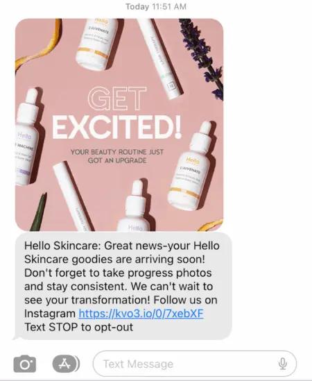 Image shows an order confirmation text from premium skincare brand Hello Skincare, which reads, “Great news-your Hello Skincare goodies are arriving soon! Don’t forget to take progress photos and stay consistent. We can’t wait to see your transformation! Follow us on Instagram.” The text includes an image featuring several of the brand’s products and a banner that reads “Get excited” at the top, plus a link to the brand’s Instagram page at the bottom.