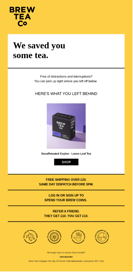 Abandoned cart email from Brew Tea Co in yellow, white, and black. The headline reads, “We saved you some tea.” Body copy reads, “Free of distractions and interruptions? You can pick up right where you left off below.” Under “Here's what you left behind,” a product image shows a Brew Tea Co box labeled “Decaffeinated Ceylon - Loose Leaf Tea” above a black “Shop” button. The bottom half lists free shipping, Brew Coins, and refer-a-friend offers, four circular brand badges, and an unsubscribe link with the company address.