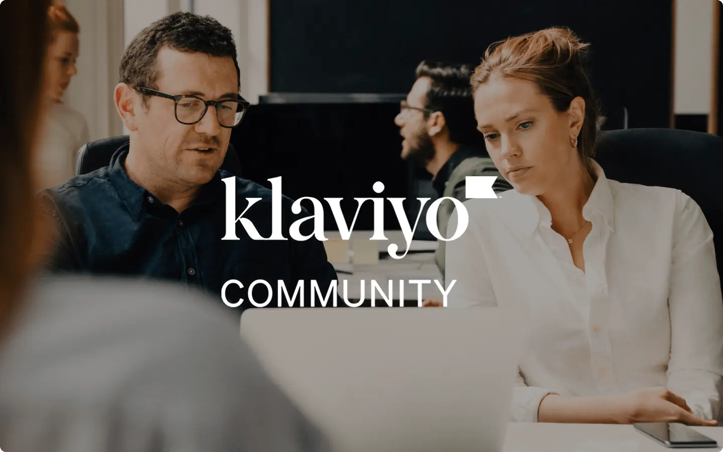 Two people working together at a desk, with "Klaviyo Community" text overlay.