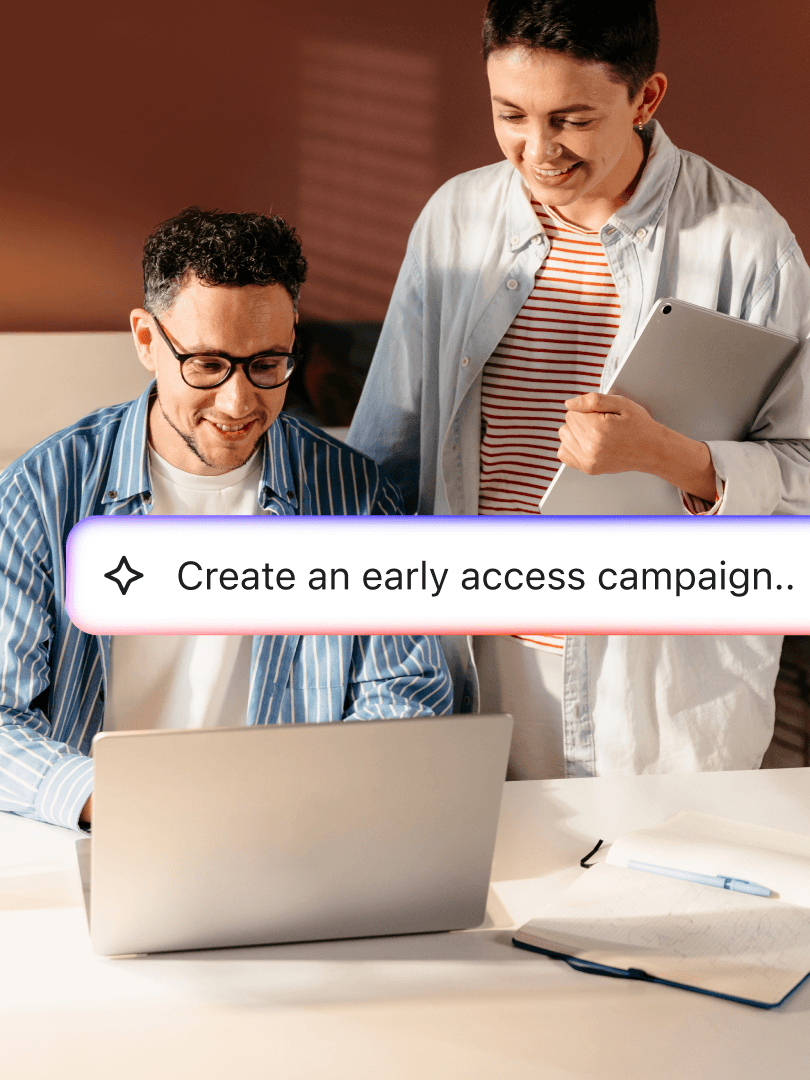 Two coworkers with a laptop and tablet create an early access campaign.