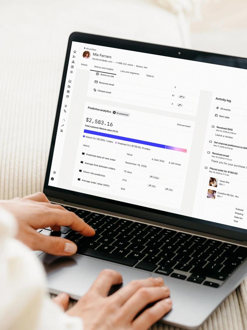 Person using a laptop displaying a customer profile, predictive analytics, and activity log.