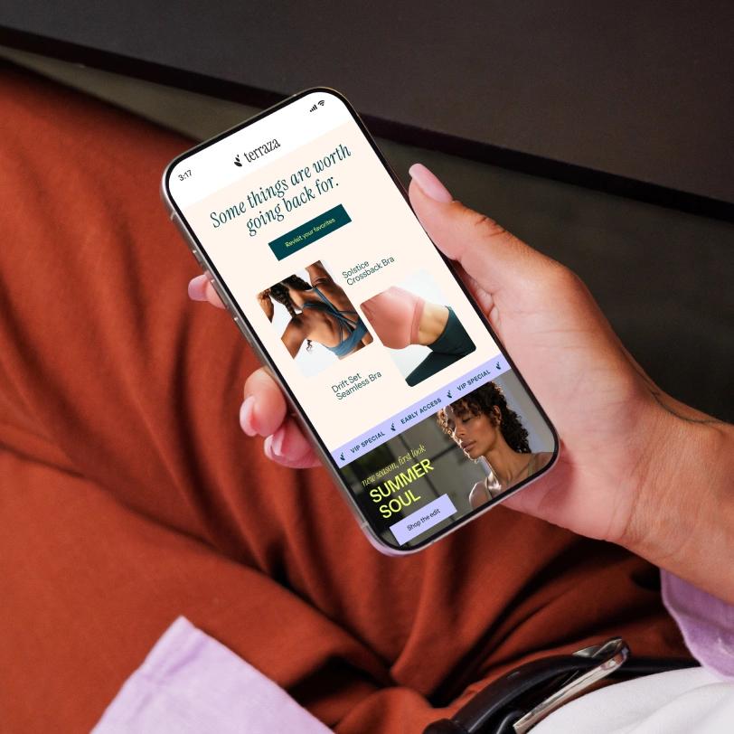 Person holding a smartphone displaying the Terezza activewear shopping website.