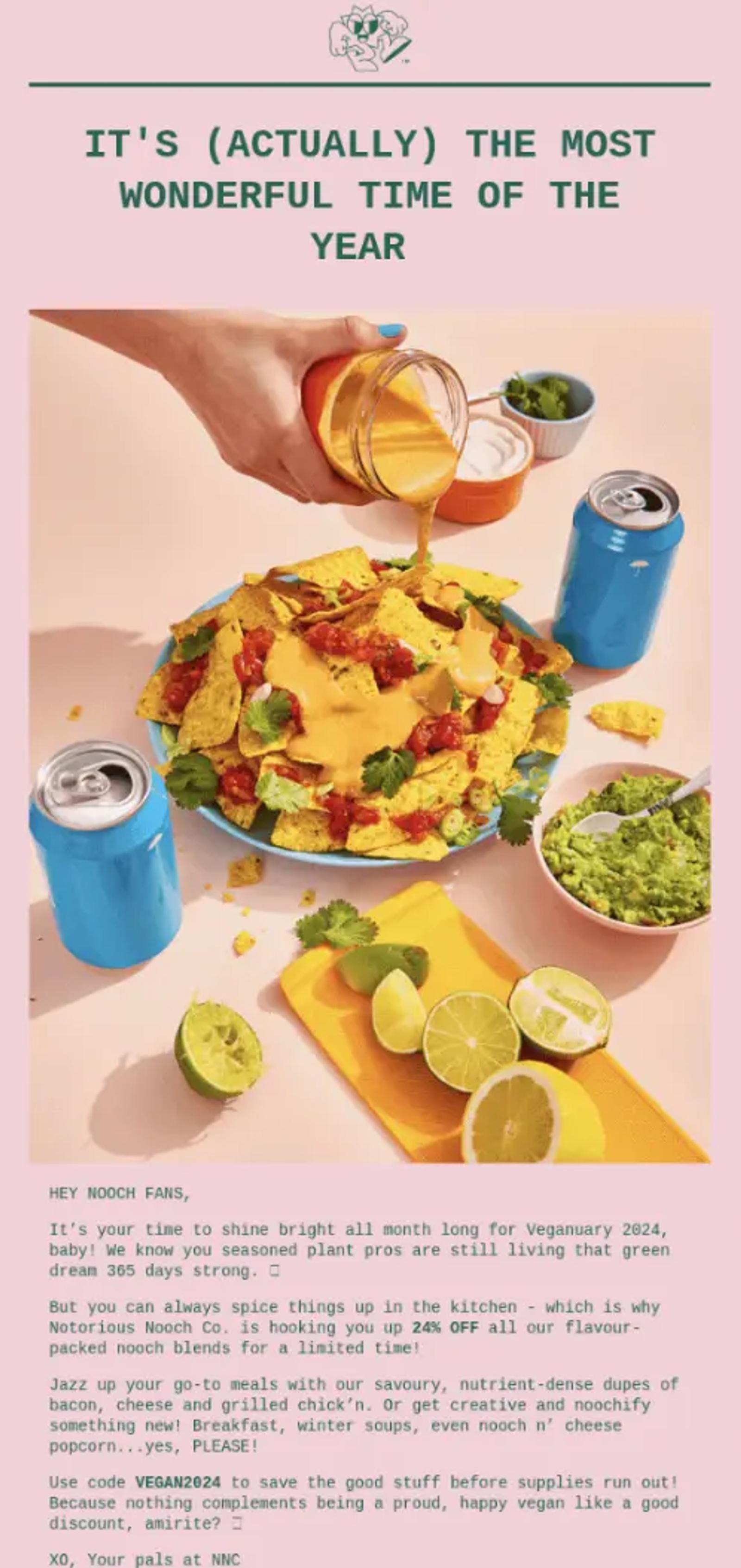 A hand pours cheese sauce over nachos with salsa and coriander. Nearby are lime slices, guacamole, and blue soda cans. Text promotes Veganuary 2024.