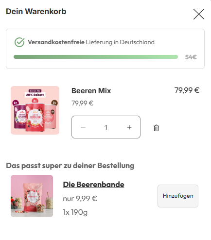 Shopping cart screen in German titled “Dein Warenkorb” showing free shipping progress, a “Beeren Mix” product priced at €79.99 with quantity controls, and a recommended item “Die Beerenbande” for €9.99 with an “Hinzufügen” (add) button.