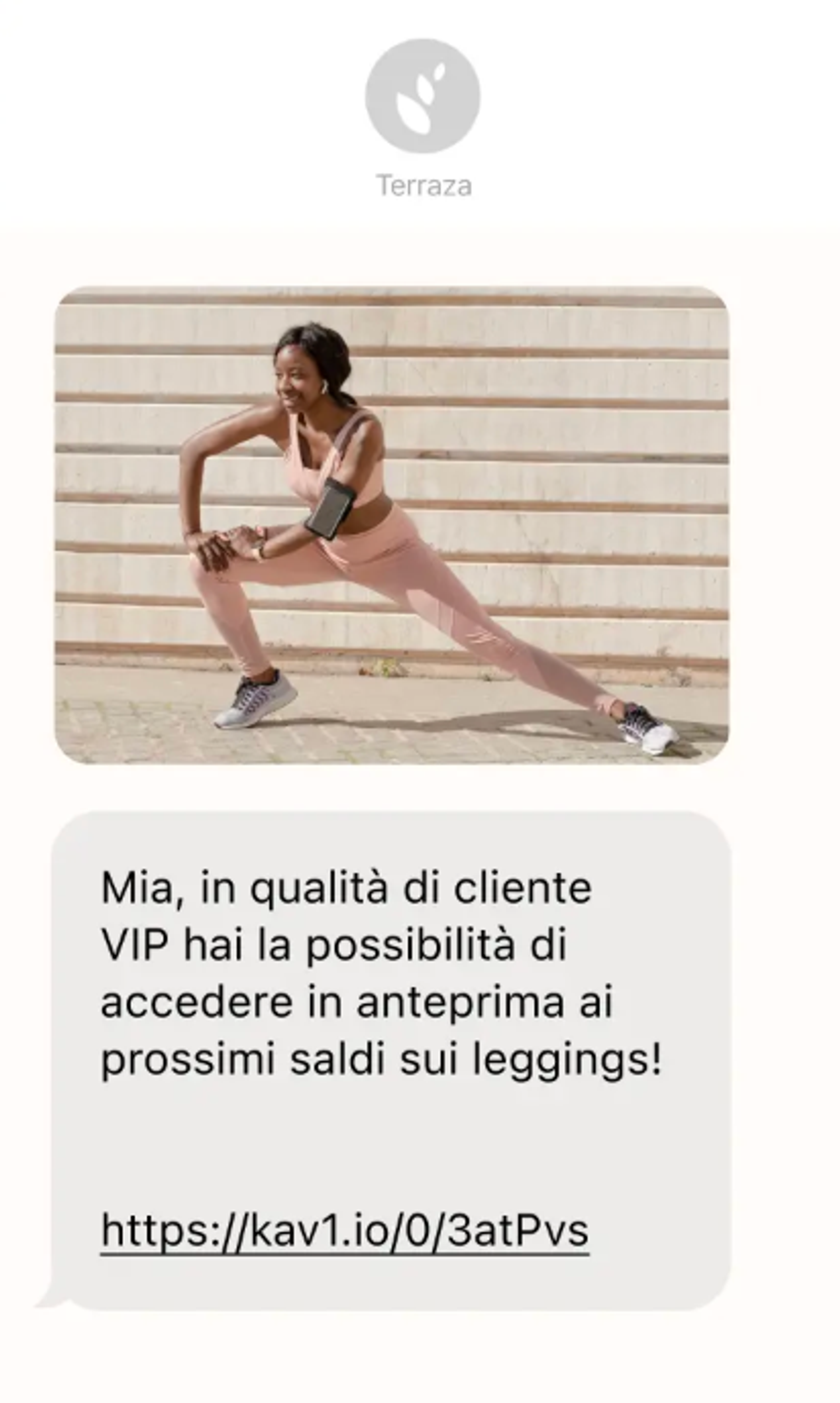 Uno screenshot di un SMS promozionale in italiano inviato da un brand di abbigliamento, contenente l'immagine di una donna che fa stretching e un link di accesso prioritario ai saldi.