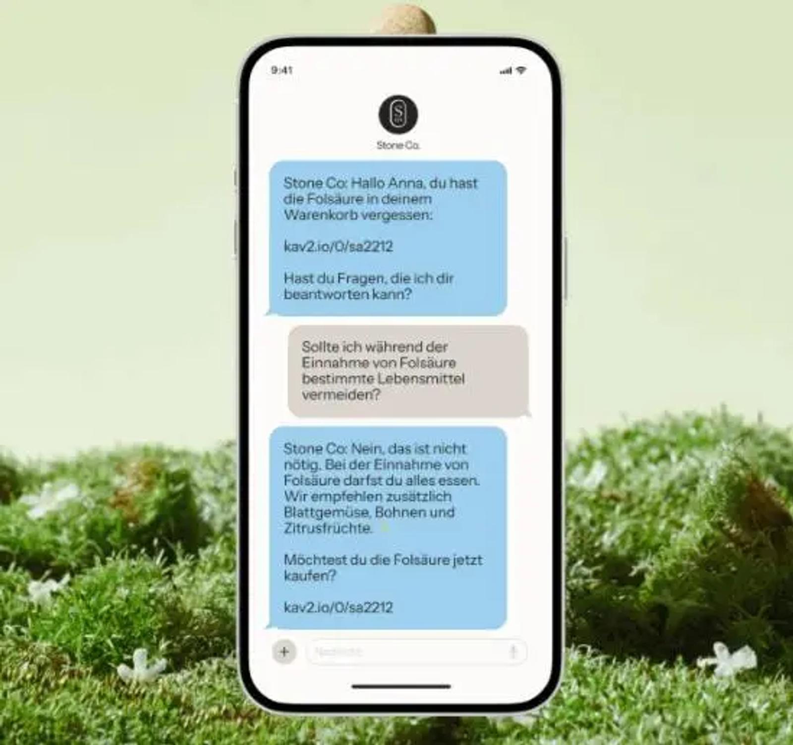 Smartphone mit SMS-Dialog über Folsäure-Warenkorbabbruch. Nachricht von "Stone Co." erinnert an vergessene Folsäure im Warenkorb.
