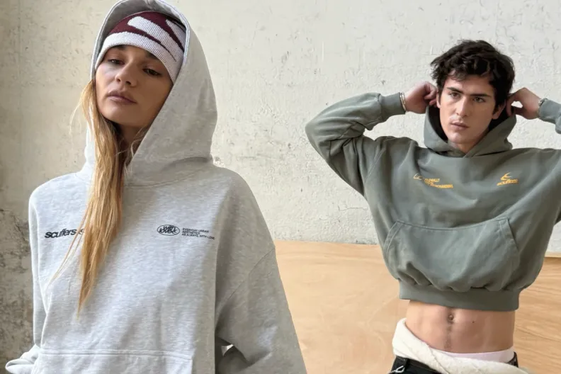 A woman in a grey hoodie and a man in a green cropped hoodie.
