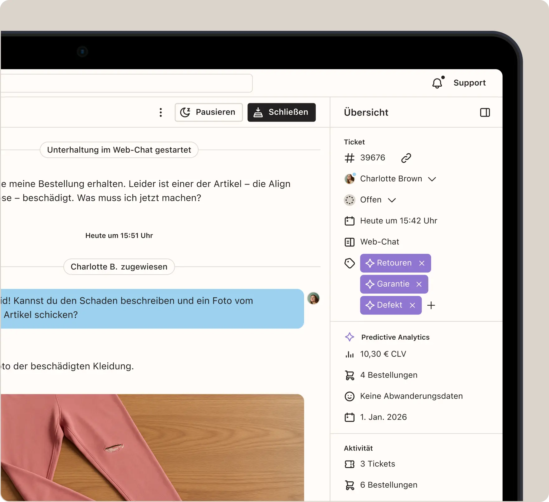 Web-Chat-Benutzeroberfläche mit Support-Ticket von Charlotte Brown. Nachricht über beschädigten Artikel und Foto eines rosa Kleidungsstücks.