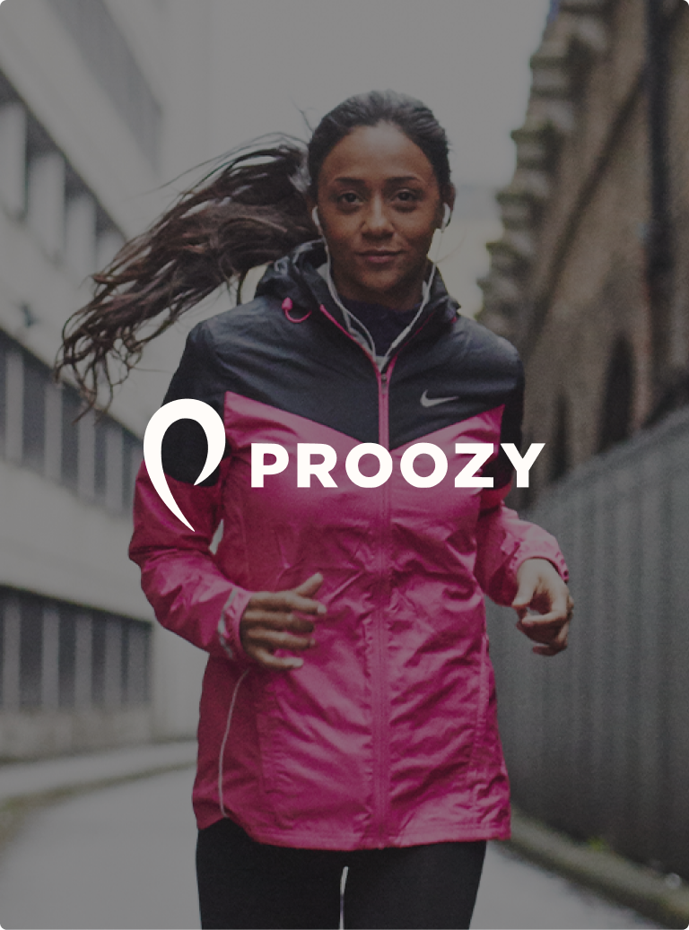 A woman running in a two-tone Nike windbreaker with headphones on a city street, overlaid with the Proozy logo