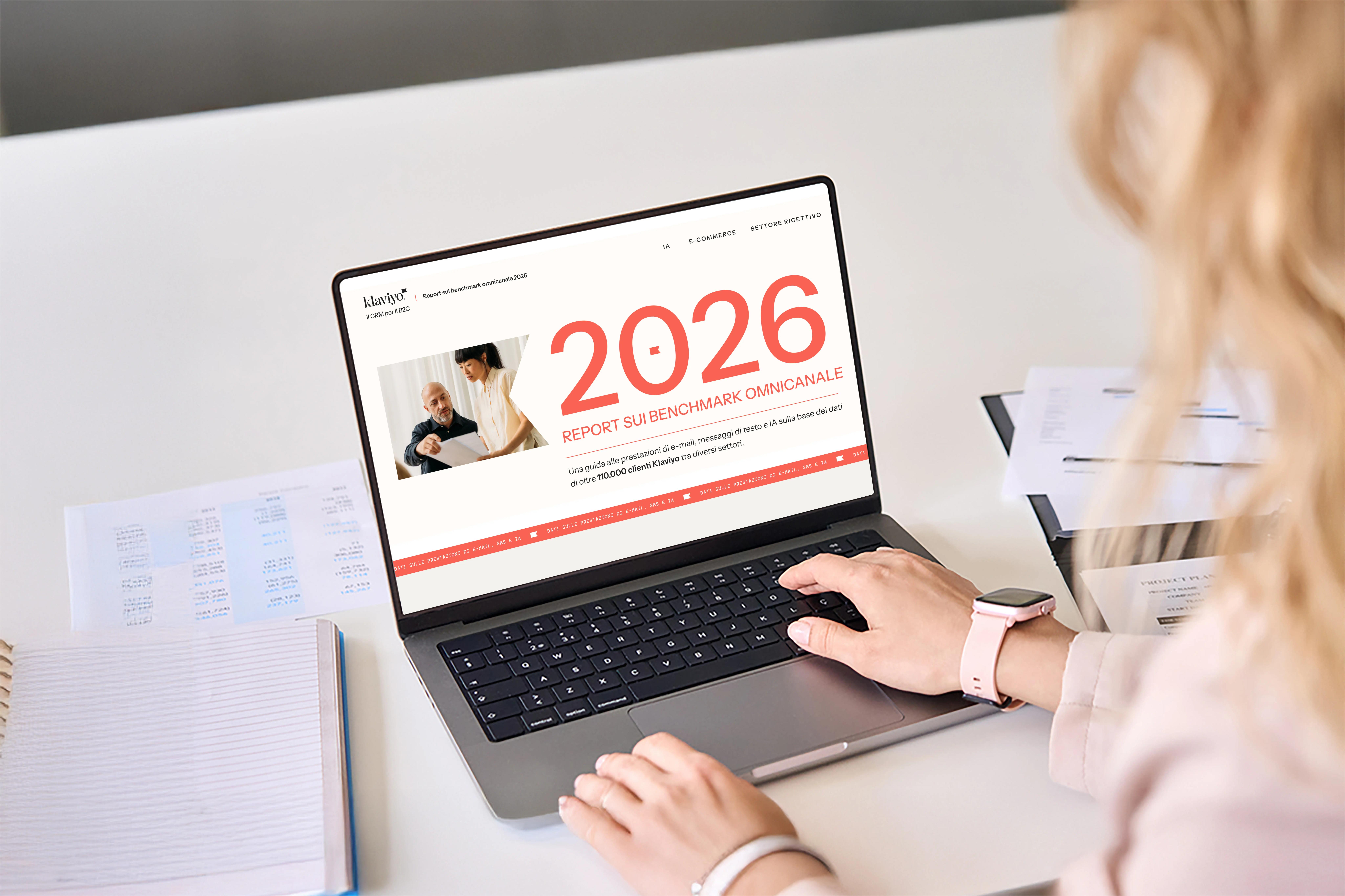 Persona che utilizza un laptop con schermo che mostra il "Report sui Benchmark Omnicanale 2026" di Klaviyo.