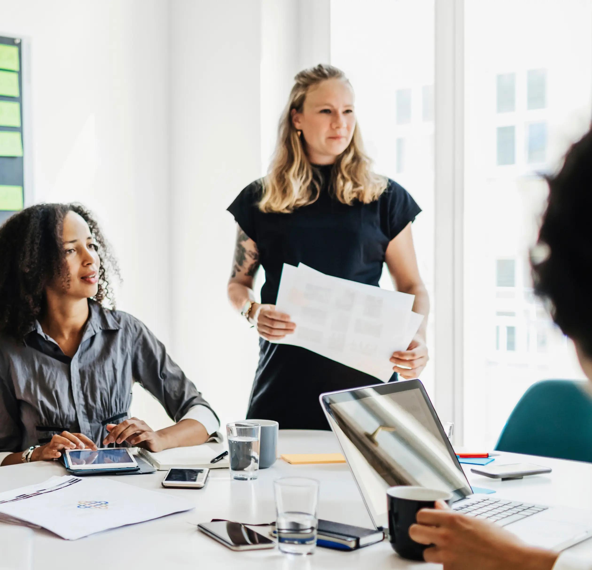 group of women working and talking at a desk