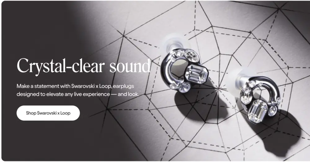 Image shows crystal-adorned earplugs that shine against strong shadows on a white, patterned surface. A headline reads, “crystal-clear sound” and a white call-to-action button reads, “Shop Swarovski x Loop.”