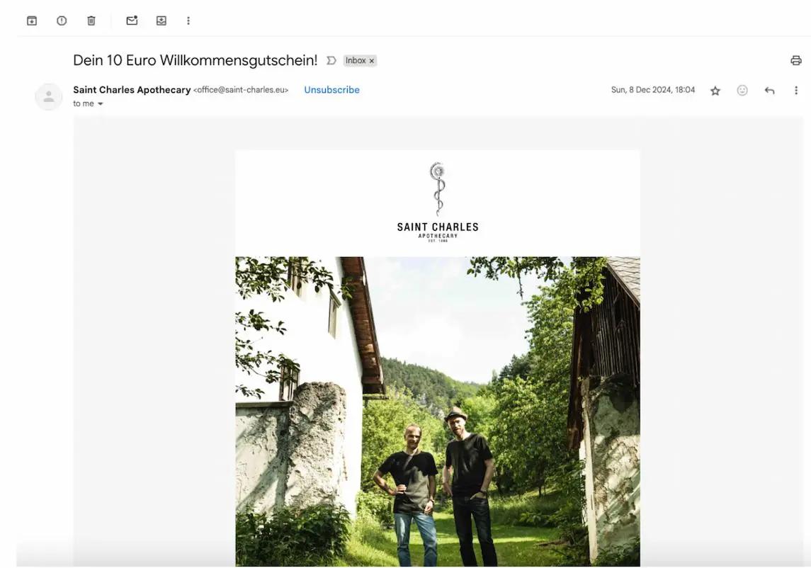 E-Mail von Saint Charles Apothecary mit Betreff "Dein 10 Euro Willkommensgutschein". Zwei Personen stehen im Freien.