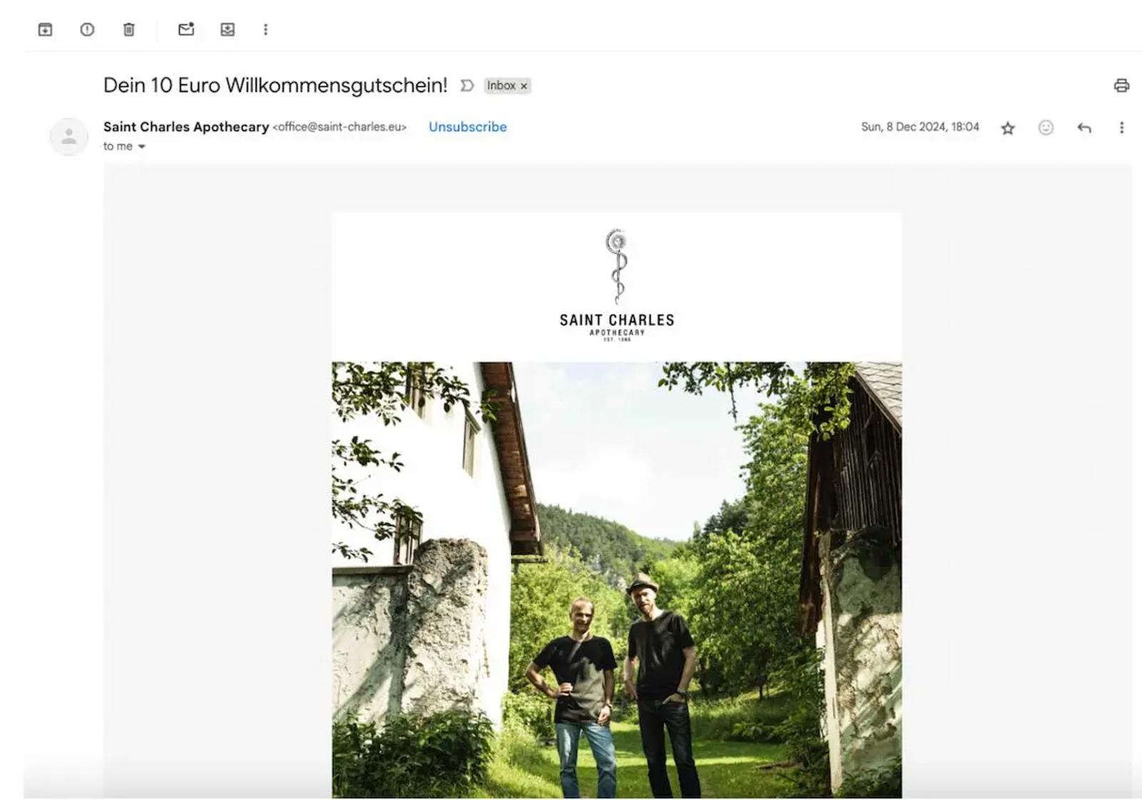 E-Mail von Saint Charles Apothecary mit Betreff "Dein 10 Euro Willkommensgutschein". Zwei Personen stehen im Freien.