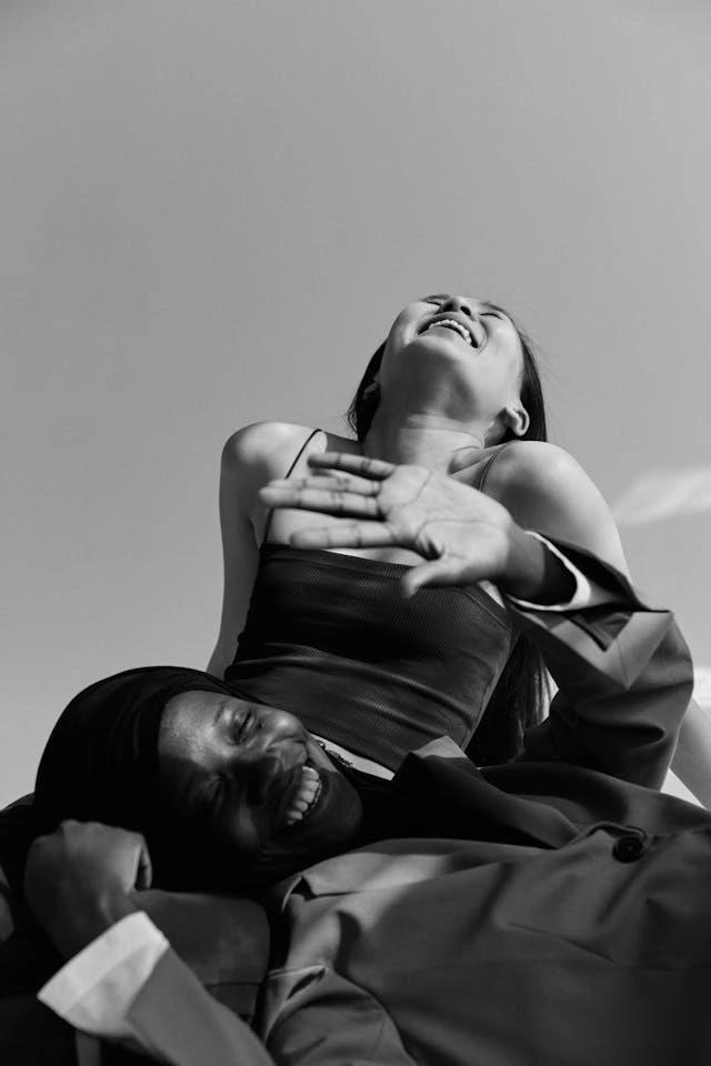 Two friends lounging together, laughing as the sun shines on their faces.