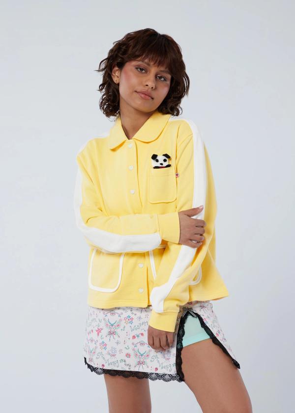 Girl wears a butter yellow peter pan collar jacket with heart snaps and a little knit puppy charm that fits in the chest pocket.