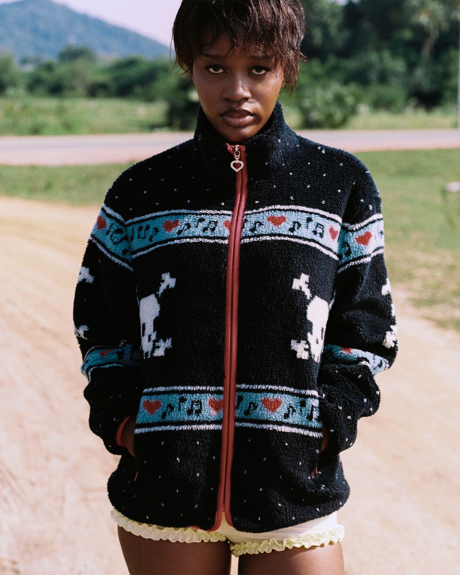 Kawaii black sherpa fleece jacket in a skull and polka dot pattern worn on a hike to a pond in Thailand.