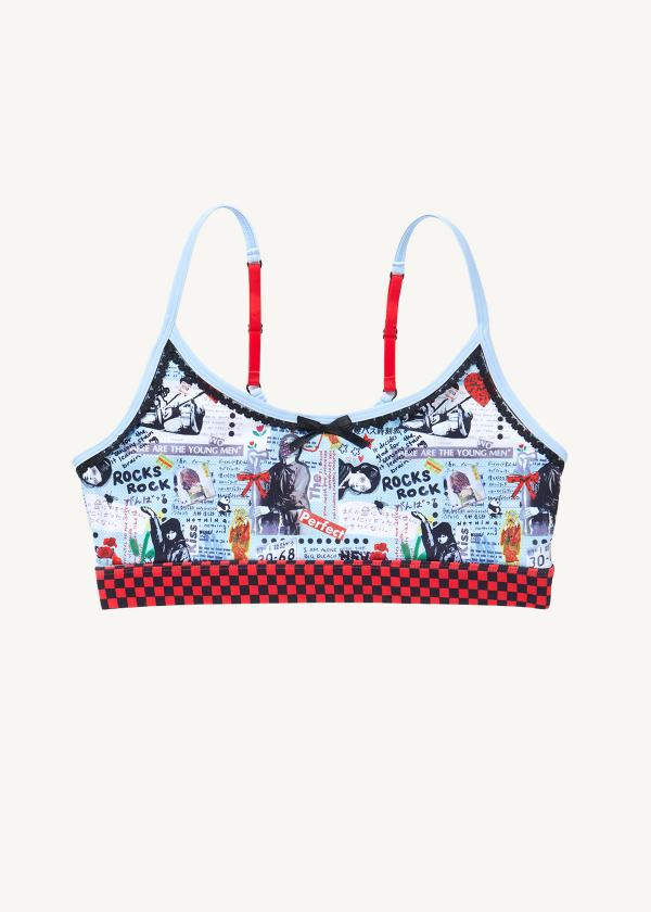 Flat front view of sports bra in punk-style collage print with red and black checker waistband and a black satin bow.