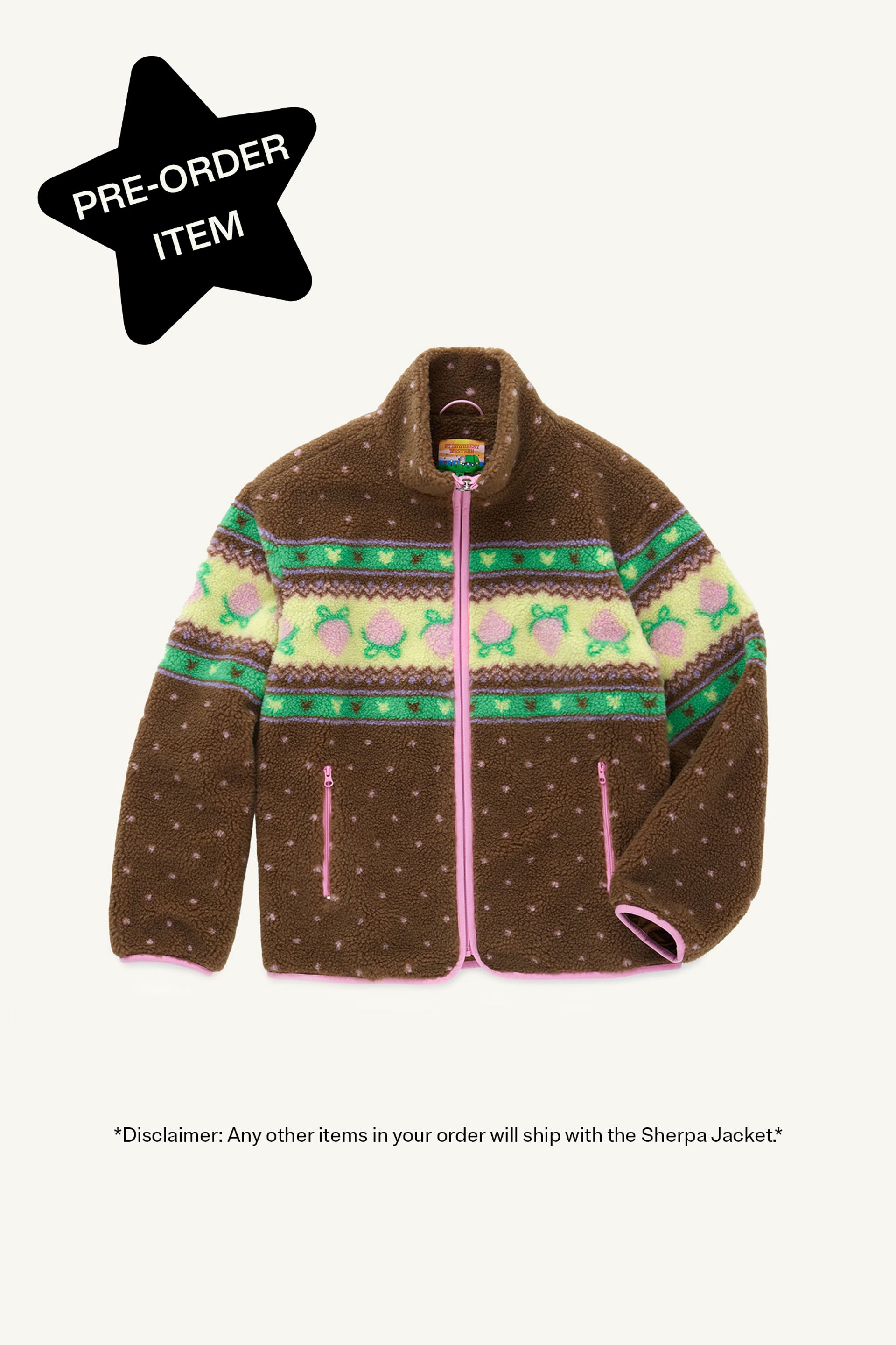 Flat front view of a Brown fluffy jacquard knit sherpa jacket in a choco strawberry border motif with binding, zippers and a metal heart shape zipper pull. Star in top left corner reads "Pre-order item"