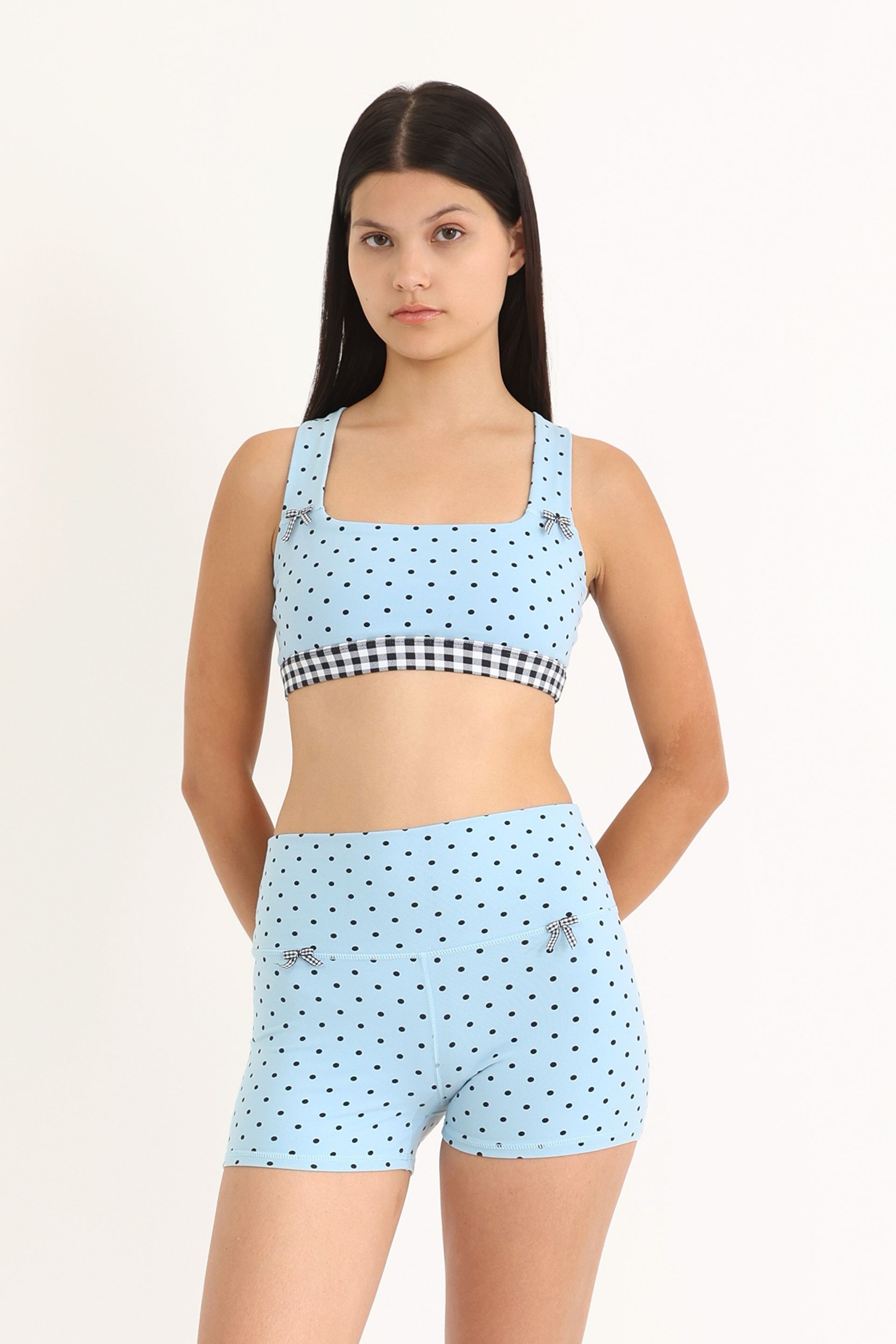 Front view of soft and supportive high-waisted yoga shorts with a fixed 3" inseam in a Blue Polka Dot print with gingham bows at the front.