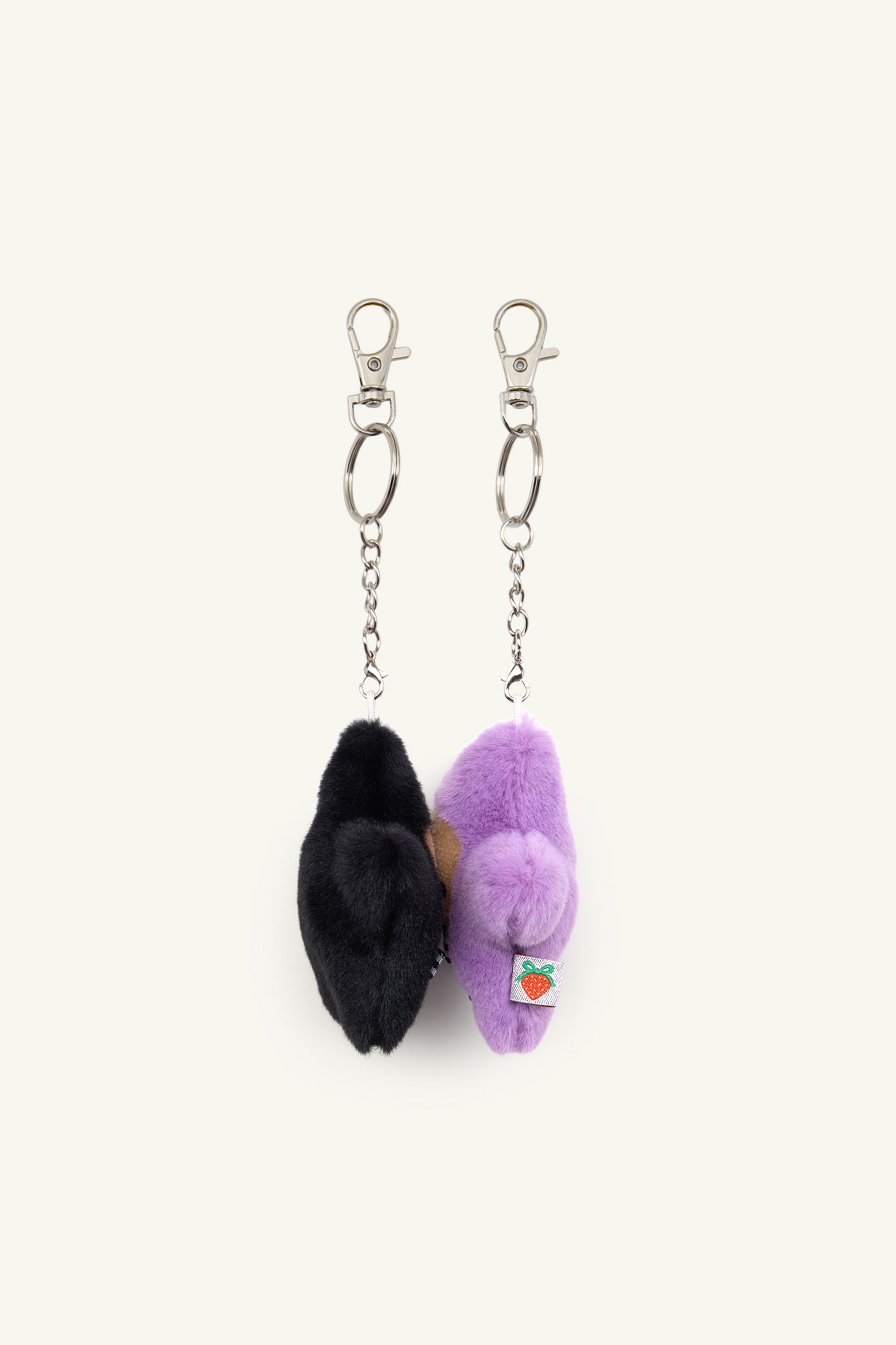 Side view product image of Black and Purple Kissing Starbaby star keychain set touching faces, showing how they connect with interior magnets.