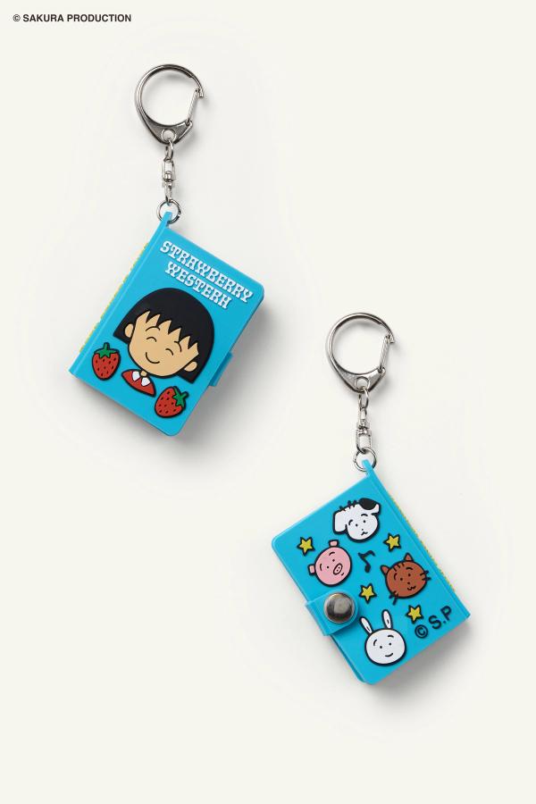 Flat image of front and back of Chibi Maruko Chan Secret Notebook. Front features Chibi Maruko-chan smiling and two strawberries. Top reads "Strawberry Western" in white lettering. Back features animal friends, stars, and music notes.