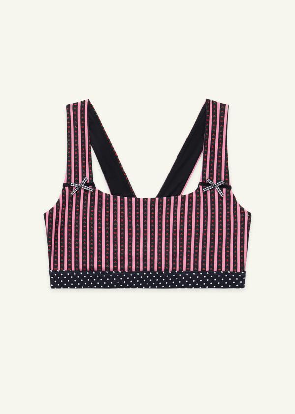 Front view of medium-support Coco Sports Bra silhouette featuring a hand-drawn, floral border stripe print in Pink/Black with contrast polka dot print elastic band and gingham bow details.