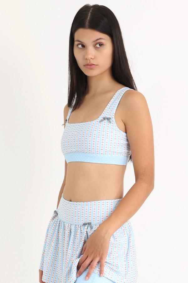 Front view of medium-support Coco Sports Bra silhouette featuring a hand-drawn, floral border stripe print in Blue/Ivory with contrast polka dot print elastic band and gingham bow details.