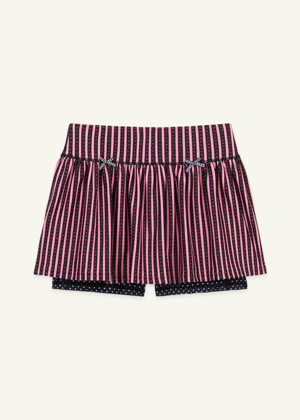 Front view of skort silhouette with gathered ruffle skirt and attached interior shorts with side pockets. Hand-drawn, pink and black floral border stripe print with contrast black and white polka dot print and gingham bow details.