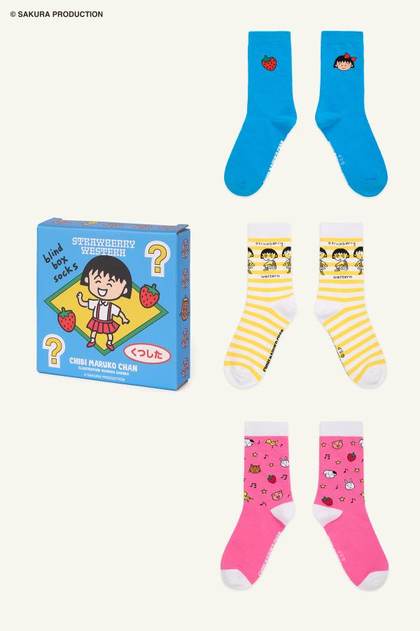 Flat image of the Blind Box and all three sock options. On top is a smiling Chibi Maruko-chan paired with our iconic strawberry against a deliciously blue knit. In the middle is Yellow and white striped pattern with black line art of Chibi Maruko-chan displaying various emotions. On the bottom, a mixed pattern of classic Chibi Maruko-chan animals with musical notes, stars, and strawberries set against a soft pink base with white rib cuff.