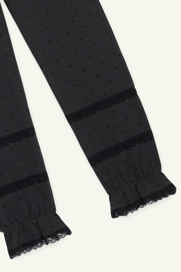 Detail view of bloomer-style sweatpants in washed black with tonal black polka dot print and cinched bloomer and black lace details at the leg openings.