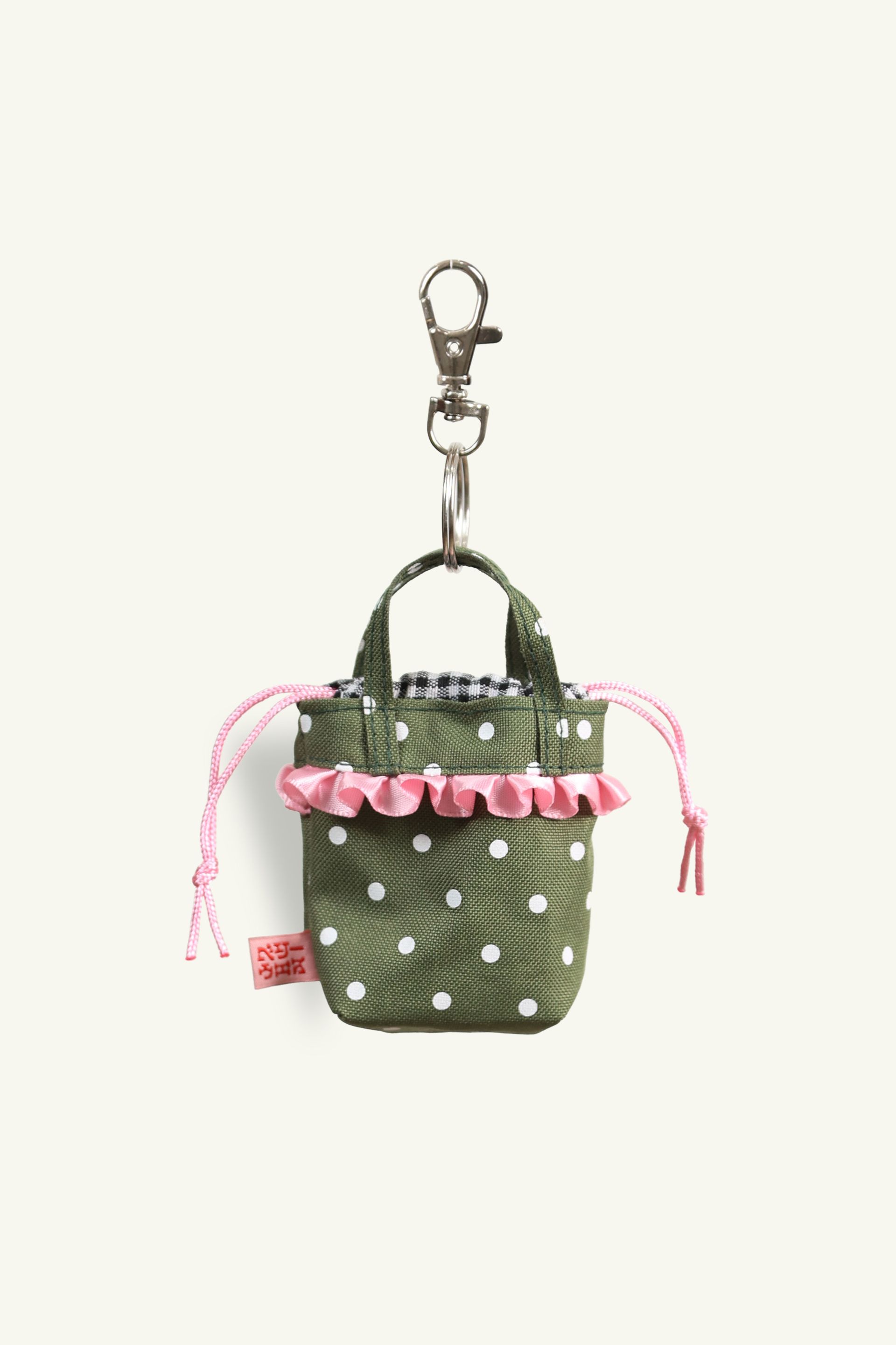Back view of Mini Ichigo Bag Keychain in Olive green with white polka dots, black and white gingham lining, baby pink bow and ruffle trim. Attached to metal key ring and trigger snap.