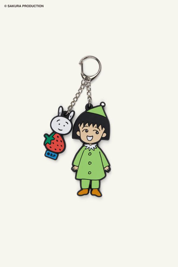 Flat image of the Chibi Maruko Chan Tomodachi Keychain. Features Chibi Maruko-chan wearing a festive, green outfit on one chain. On the other chain is her bunny friend stacked on top of a strawberry.