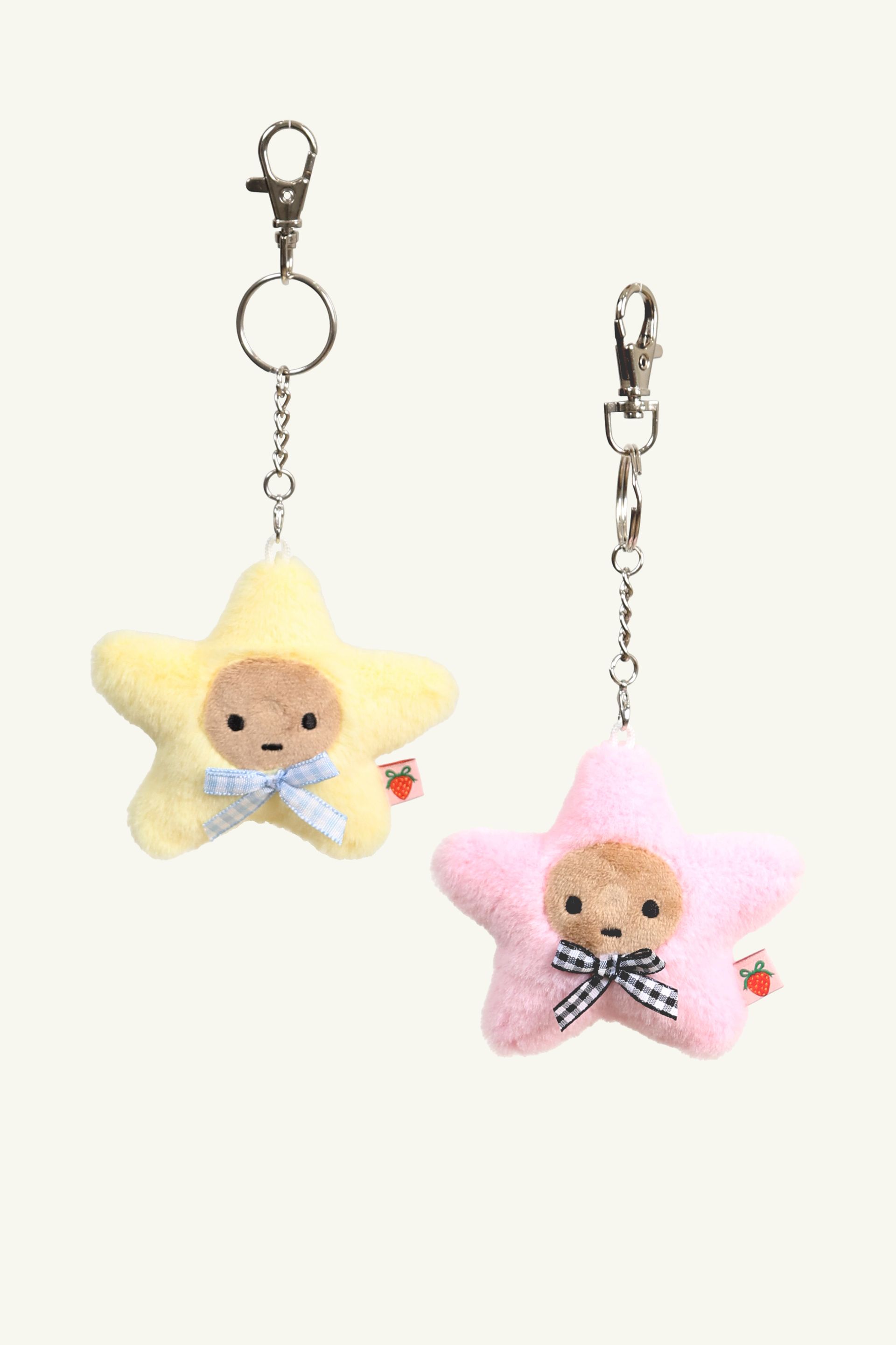 Pink Yellow Kissing Starbaby star-shaped keychain set each with a small face, checkered bow, and metal clasp.