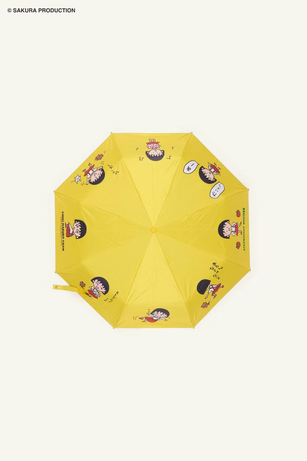 Flat image of open Chibi Maruko Chan yellow umbrella. Each panel features a different version of Chibi Maruko-chan.