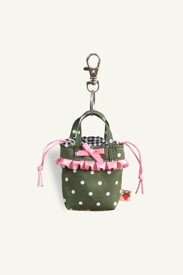 Front view of Mini Ichigo Bag Keychain in Olive green with white polka dots, black and white gingham lining, baby pink bow and ruffle trim. Attached to metal key ring and trigger snap.