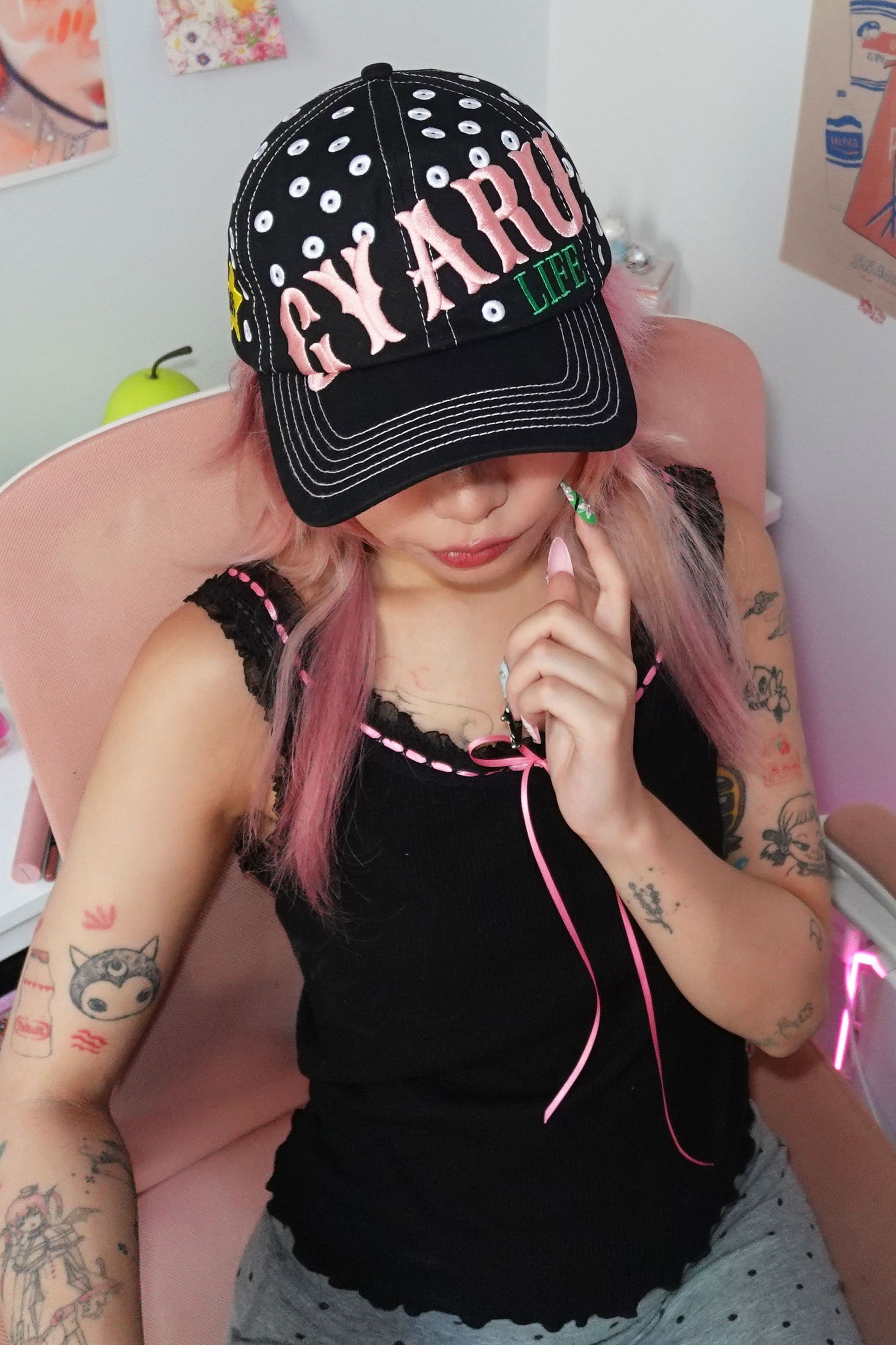 Black baseball cap with allover embroidered white polka dots and a pink and green embroidery at front that say 'GYARU LIFE'.