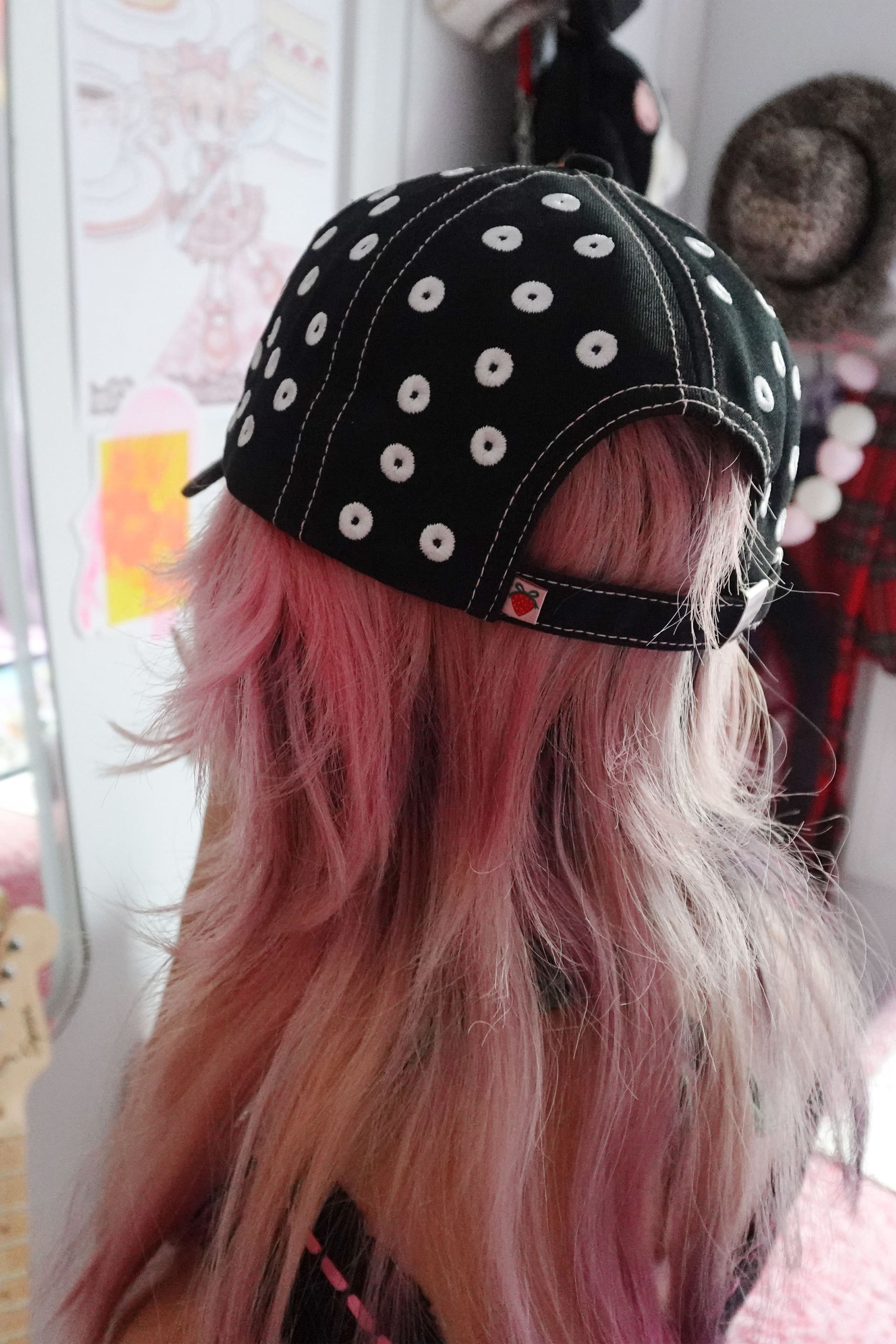 Black baseball cap with allover embroidered white polka dots and a pink and green embroidery at front that say 'GYARU LIFE'.